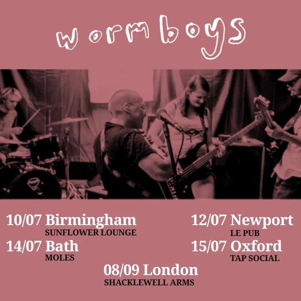 Tour poster for wormboys. The poster is saturated salmon pink, with a photograph of four people playing instruments closely together, and a list of dates.